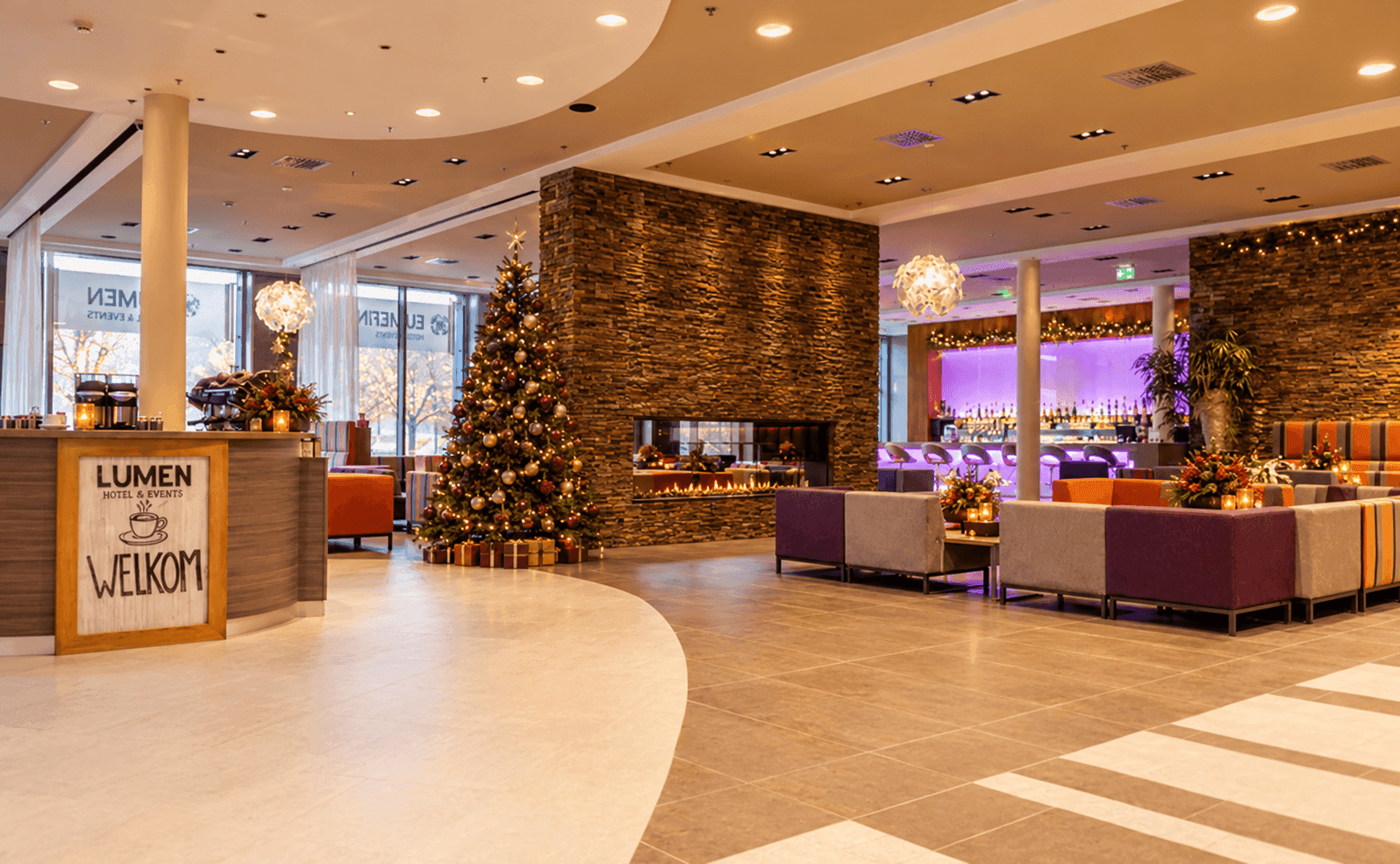 Feestelijke hotel_lounge met kerstboom en haard.png